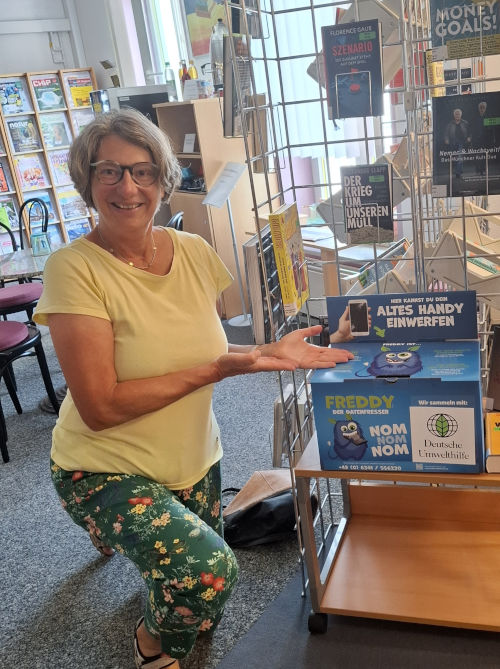 Zu sehen ist Sabine Canditt neben einer Handy-Sammelbox der Deutschen Umwelthilfe